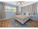 Cozy bedroom featuring a queen bed, wood floors, and a ceiling fan, complete with decor, side tables and lamps at 12384 144Th St, Largo, FL 33774