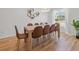 Dining room featuring seating for ten, hardwood floors, a modern light fixture, and natural light from the large window at 12384 144Th St, Largo, FL 33774