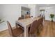 Dining room with seating for ten, hardwood floors, modern decor, and natural light from a large window at 12384 144Th St, Largo, FL 33774