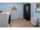 Well-lit laundry room with washer, dryer, storage cabinet, tiled floor, and two windows at 12384 144Th St, Largo, FL 33774