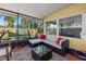 Covered patio with comfortable sectional seating and a glass top table overlooking the backyard at 12384 144Th St, Largo, FL 33774