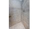 Close-up of shower with beige square tiled walls and mosaic tile floor at 124 Nina Way # 24, Oldsmar, FL 34677