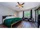 Primary bedroom with ceiling fan, hardwood floors, and large window at 124 Nina Way # 24, Oldsmar, FL 34677