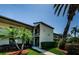 Condo exterior with mature palms and landscaping. The front entrance and private balcony offer curb appeal and outdoor living at 124 Nina Way # 24, Oldsmar, FL 34677