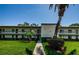 Inviting condo with manicured lawn and mature landscaping. A sidewalk leads to the front entrance of the well-maintained building at 124 Nina Way # 24, Oldsmar, FL 34677