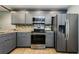 Modern kitchen features gray cabinets and stainless steel appliances at 124 Nina Way # 24, Oldsmar, FL 34677