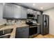 Kitchen featuring gray cabinets, stainless steel appliances, and granite countertops at 124 Nina Way # 24, Oldsmar, FL 34677