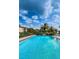 Community pool surrounded by lush trees and lounge chairs at 124 Nina Way # 24, Oldsmar, FL 34677