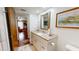 Bathroom featuring a vanity with a sink and framed mirror plus an open doorway to another room at 12485 2Nd E St # C103, Treasure Island, FL 33706