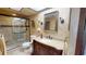 Bathroom featuring tiled floors, elegant vanity, framed mirror, sconces, and glass-enclosed shower at 12485 2Nd E St # C103, Treasure Island, FL 33706