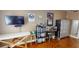 Bright bedroom featuring wood flooring, a television, and storage shelves along the wall at 12485 2Nd E St # C103, Treasure Island, FL 33706