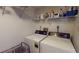Laundry room with side-by-side washer and dryer and white wire rack shelving at 12485 2Nd E St # C103, Treasure Island, FL 33706