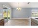 The dining area features a sliding glass door, wood flooring and a modern light fixture at 13193 Paxton Ave, Weeki Wachee, FL 34614