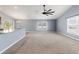 Well-lit living room featuring large windows, neutral carpet, and easy access to the kitchen at 13193 Paxton Ave, Weeki Wachee, FL 34614