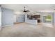 Open-concept layout connecting the carpeted living area, wood-look floors, and modern kitchen at 13193 Paxton Ave, Weeki Wachee, FL 34614
