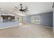 Bright and airy living room with a modern ceiling fan, neutral carpet, and large windows at 13193 Paxton Ave, Weeki Wachee, FL 34614
