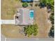 Aerial view showcasing the home with a screened pool, driveway, and landscaping at 13290 Don Loop, Spring Hill, FL 34609