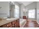 Bright bathroom with dual vanity sinks, a soaking tub, and tile flooring at 13290 Don Loop, Spring Hill, FL 34609