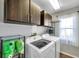 Convenient laundry room with modern washer, dryer, and ample storage cabinets at 13290 Don Loop, Spring Hill, FL 34609