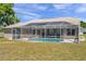 Home's rear exterior featuring a screened-in pool, perfect for outdoor enjoyment at 13290 Don Loop, Spring Hill, FL 34609