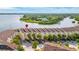 Aerial view of waterfront townhomes with lush landscaping, waterfront views, and convenient garage parking at 140 Brent Cir, Oldsmar, FL 34677