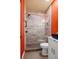 Modern bathroom with glass enclosed shower, sleek vanity, and contrasting orange wall at 140 Brent Cir, Oldsmar, FL 34677