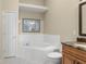 Bright bathroom featuring a soaking tub, tile floors, and a granite-topped vanity at 140 Brent Cir, Oldsmar, FL 34677