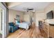 Spacious bedroom with hardwood floors, a ceiling fan, and doorway to the ensuite bathroom at 140 Brent Cir, Oldsmar, FL 34677