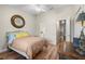 A spacious bedroom with hardwood floors, ceiling fan, and decorative mirror at 140 Brent Cir, Oldsmar, FL 34677