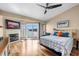 Inviting bedroom with a fireplace, hardwood floors, and private balcony overlooking the water at 140 Brent Cir, Oldsmar, FL 34677