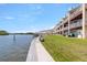 Waterfront condo community with lush green lawn and serene water views at 140 Brent Cir, Oldsmar, FL 34677
