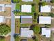 Aerial view of a well-maintained neighborhood with lush landscaping, and many homes with white roofs at 14383 Dehaven Ave, Brooksville, FL 34613