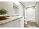 This bathroom has white cabinetry with granite countertops and shower-tub combo at 14383 Dehaven Ave, Brooksville, FL 34613