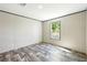 This bedroom features gray wood floors and a window for natural lighting at 14383 Dehaven Ave, Brooksville, FL 34613