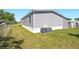 Exterior view showing grass, landscaping, an air conditioning unit, and partial fencing at 14383 Dehaven Ave, Brooksville, FL 34613
