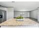 Granite-topped kitchen island offers seating and prep space, overlooking the open-concept living area at 14383 Dehaven Ave, Brooksville, FL 34613