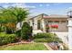 Charming single-Gathering home showcasing a well-manicured lawn, mature trees, and a two-car garage at 1511 Woonsocket Ln, Brandon, FL 33511