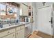 Kitchen area showcasing a stainless steel sink, tiled backsplash, and white cabinetry at 1511 Woonsocket Ln, Brandon, FL 33511