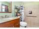 Well-maintained bathroom with a tiled shower, updated vanity, and convenient storage shelving at 1528 Chevy Chase Dr, Sun City Center, FL 33573