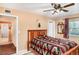 Cozy bedroom featuring a ceiling fan, a colorful bedspread, neutral walls, and ensuite access at 1528 Chevy Chase Dr, Sun City Center, FL 33573
