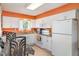 Bright kitchen featuring white cabinets, stainless steel appliances, and a cozy dining area at 1528 Chevy Chase Dr, Sun City Center, FL 33573