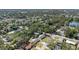 Expansive aerial shot of a neighborhood featuring lush trees, a nearby lake, and surrounding community at 1601 Paloma Ln, Dunedin, FL 34698