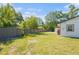 Spacious backyard with a storage shed and lush green lawn, surrounded by a wooden fence at 1601 Paloma Ln, Dunedin, FL 34698