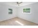 Bright bedroom featuring neutral paint, new floors, a ceiling fan, and two windows at 1601 Paloma Ln, Dunedin, FL 34698