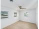 Bright bedroom featuring a ceiling fan and hardwood flooring with ample natural light at 1601 Paloma Ln, Dunedin, FL 34698