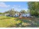 Well-maintained home featuring a lush front yard with colorful plants and mature trees at 1601 Paloma Ln, Dunedin, FL 34698