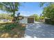 Detached garage with an extended driveway surrounded by greenery, and landscaping at 1601 Paloma Ln, Dunedin, FL 34698