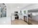A bright kitchen featuring stainless steel appliances and pristine white cabinets at 1601 Paloma Ln, Dunedin, FL 34698