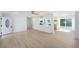 Bright, open-concept living room with modern flooring flowing seamlessly into a kitchen and dining area at 1601 Paloma Ln, Dunedin, FL 34698