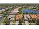 Aerial view showcases several homes, lush landscaping, and peaceful lake views at 16055 Golden Lakes Dr, Wimauma, FL 33598